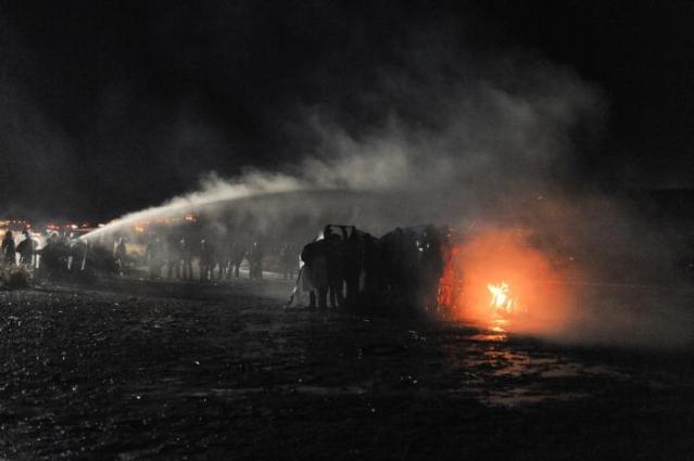 Police use a water cannon to put out a fire started by protesters during a protest against plans to pass the Dakota Access pipeline near the Standing Rock Indian Reservation, near Cannon Ball, North Dakota, U.S.