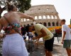 Rome, Italy. A woman pours water on a man near the Colosseum, during a heatwave across Italy, as temperatures are expected to rise further in the coming days.