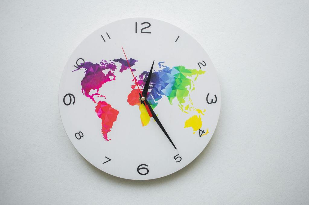 A wall clock with a colourful world map design.
