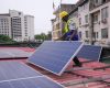 An engineer with renewables company Rensource Energy installs solar panels on the roof of a house in Lagos.
